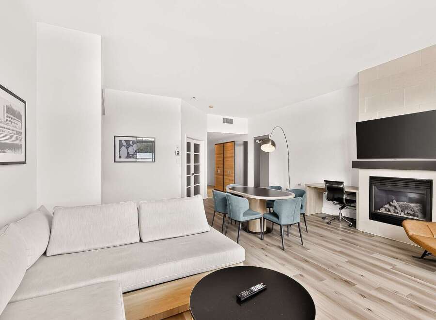 Experience modern living in this spacious suite featuring a comfortable sectional sofa and a sleek dining area perfect for entertaining.