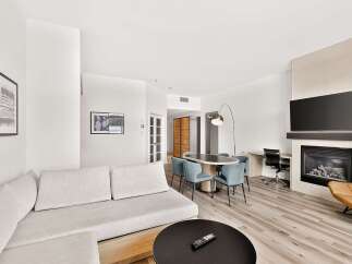 Experience modern living in this spacious suite featuring a comfortable sectional sofa and a sleek dining area perfect for entertaining.