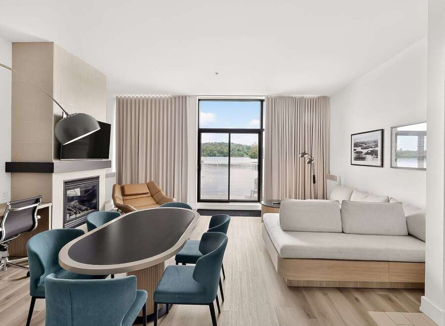 Experience modern living in this spacious suite featuring a cozy fireplace and a large dining area perfect for entertaining.