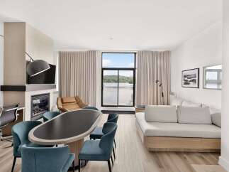 Experience modern living in this spacious suite featuring a cozy fireplace and a large dining area perfect for entertaining.