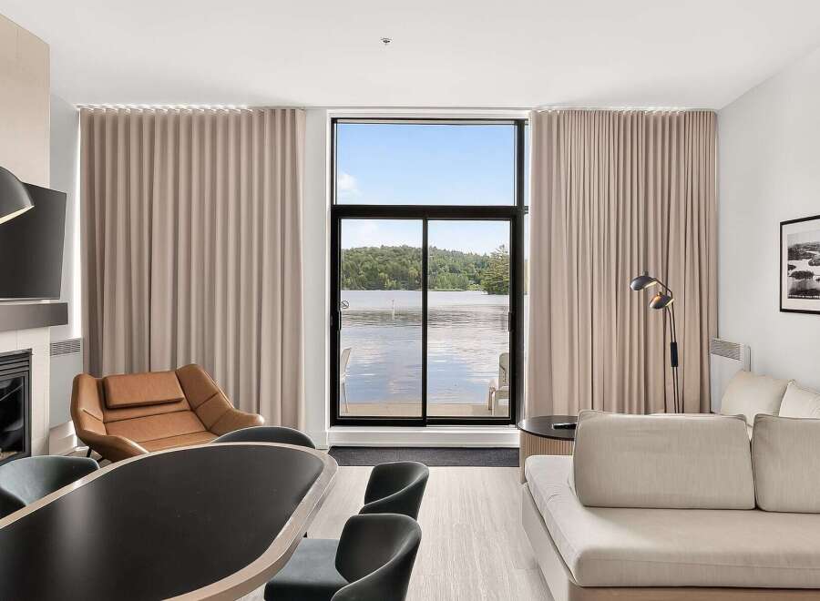 Experience breathtaking lake views from this stunning living space, featuring a modern fireplace and comfortable seating.