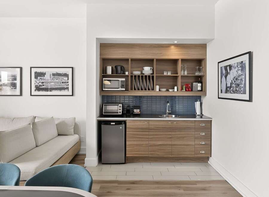 This stylish studio apartment features a compact kitchenette equipped with a microwave, toaster oven, and mini-fridge, perfect for preparing light meals.