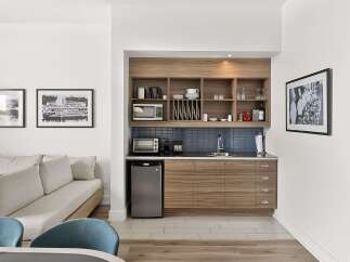 This stylish studio apartment features a compact kitchenette equipped with a microwave, toaster oven, and mini-fridge, perfect for preparing light meals.