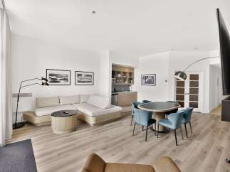 Experience modern living in this stylish open-concept suite, featuring a spacious sectional sofa and a sleek dining area perfect for entertaining.