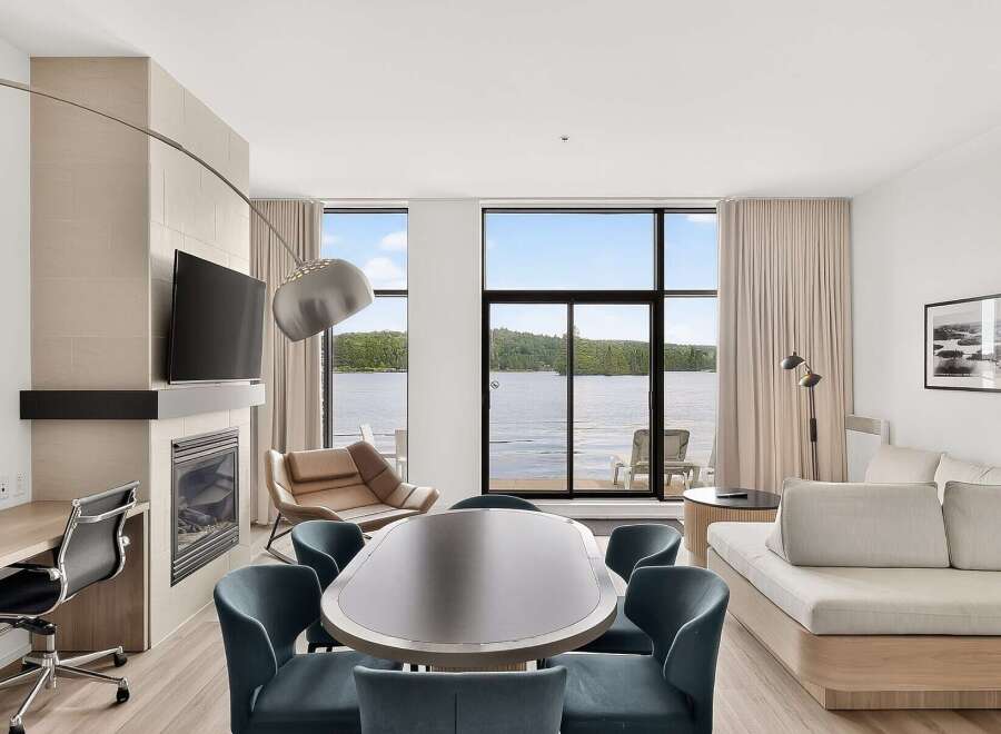 Experience luxury living with this stunning lakefront suite, featuring a modern fireplace and a spacious dining area perfect for entertaining.