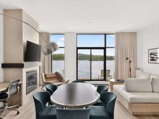 Experience luxury living with this stunning lakefront suite, featuring a modern fireplace and a spacious dining area perfect for entertaining.