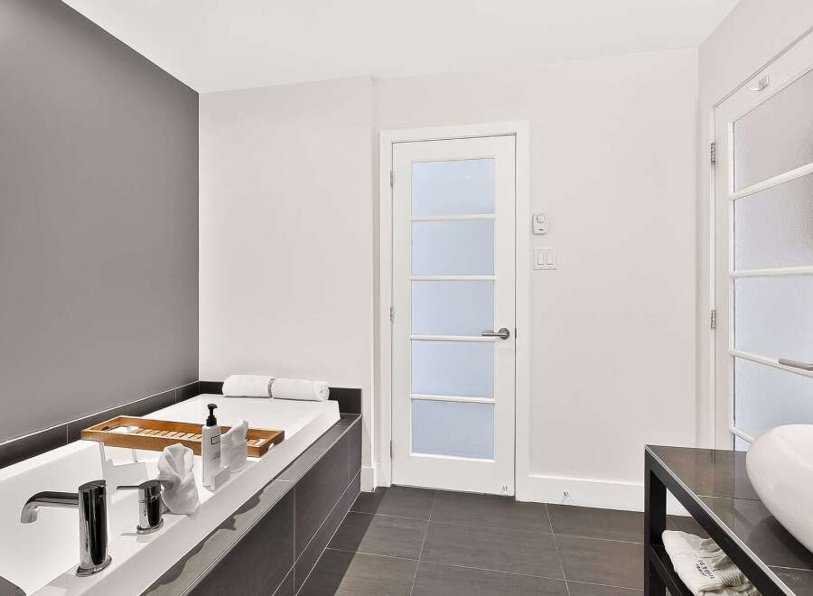 Indulge in relaxation in this luxurious bathroom featuring a deep soaking tub with a wooden tray, perfect for holding bath essentials.