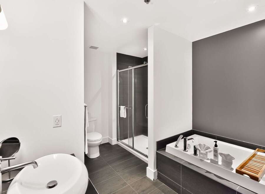 Experience luxury in this modern bathroom featuring a deep soaking tub and a separate glass-enclosed shower.