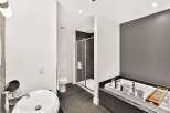 Experience luxury in this modern bathroom featuring a deep soaking tub and a separate glass-enclosed shower.
