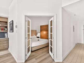 Discover modern living in this stylish studio apartment, featuring a convenient kitchenette with ample cabinet space and a chic tiled backsplash.