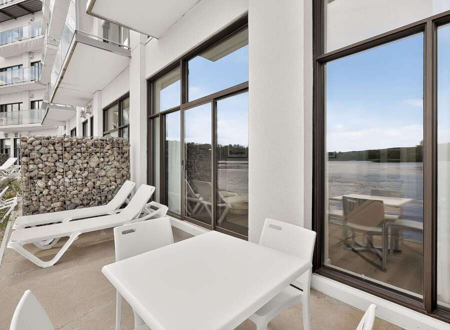 Enjoy stunning waterfront views from this modern apartment's private balcony, perfect for relaxing or entertaining.