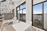 Enjoy stunning waterfront views from this modern apartment's private balcony, perfect for relaxing or entertaining.