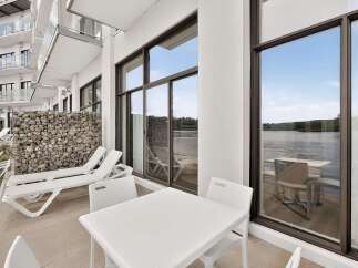 Enjoy stunning waterfront views from this modern apartment's private balcony, perfect for relaxing or entertaining.