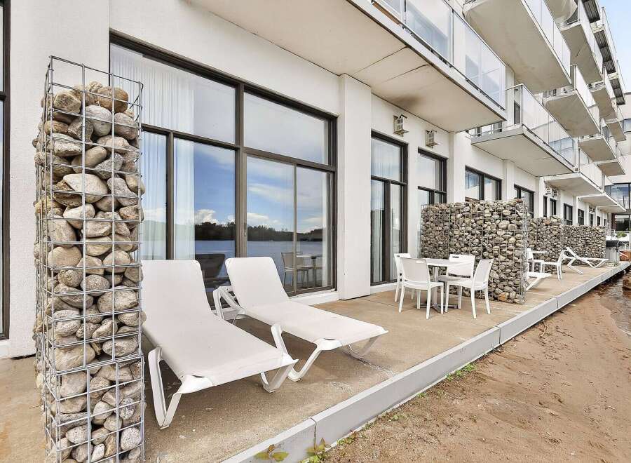 Enjoy waterfront living with this modern property featuring a spacious patio overlooking the water.