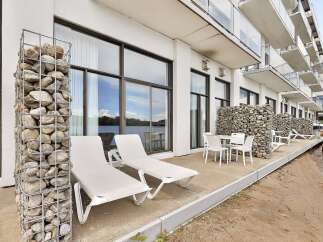 Enjoy waterfront living with this modern property featuring a spacious patio overlooking the water.