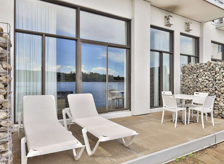 Enjoy stunning lake views from this modern patio, perfect for relaxation and outdoor dining.