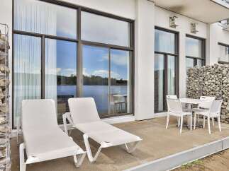 Enjoy stunning lake views from this modern patio, perfect for relaxation and outdoor dining.
