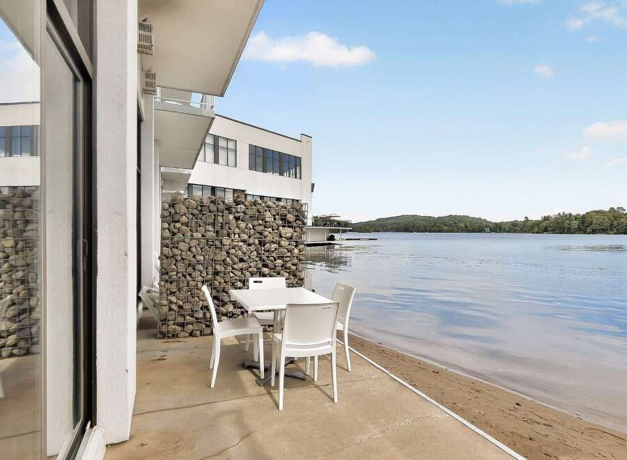Enjoy breathtaking lake views from this modern property, featuring a stylish outdoor dining area perfect for al fresco meals.
