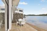 Enjoy breathtaking lake views from this modern property, featuring a stylish outdoor dining area perfect for al fresco meals.