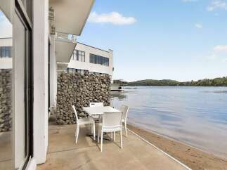 Enjoy breathtaking lake views from this modern property, featuring a stylish outdoor dining area perfect for al fresco meals.