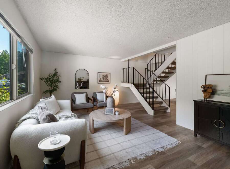 Discover this inviting living space featuring a plush white sofa and two comfortable armchairs, perfect for relaxation.