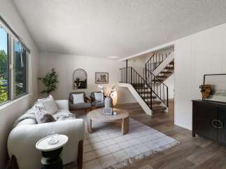 Discover this inviting living space featuring a plush white sofa and two comfortable armchairs, perfect for relaxation.