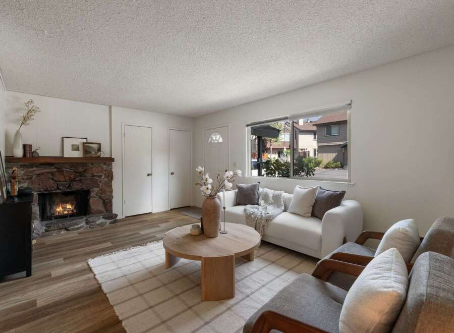 Cozy living room featuring a rustic stone fireplace, perfect for gathering on cool evenings.