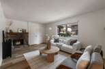 Cozy living room featuring a rustic stone fireplace, perfect for gathering on cool evenings.