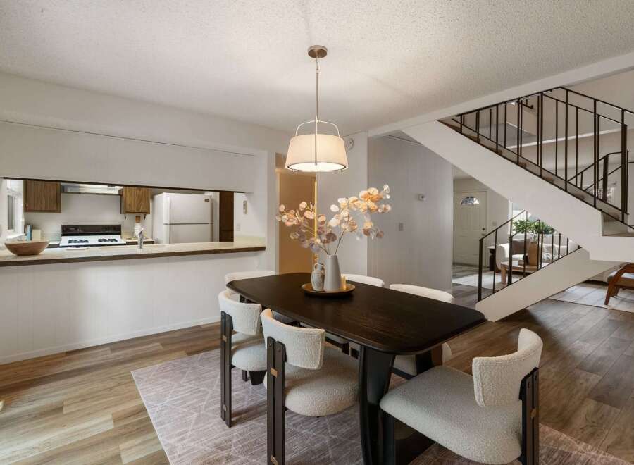 Experience modern living in this open-concept dining area, seamlessly connected to a functional kitchen with ample counter space and a breakfast bar.