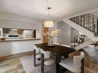Experience modern living in this open-concept dining area, seamlessly connected to a functional kitchen with ample counter space and a breakfast bar.