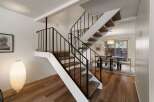 Ascend to the upper level via a striking staircase featuring a modern black railing and plush carpeted steps.