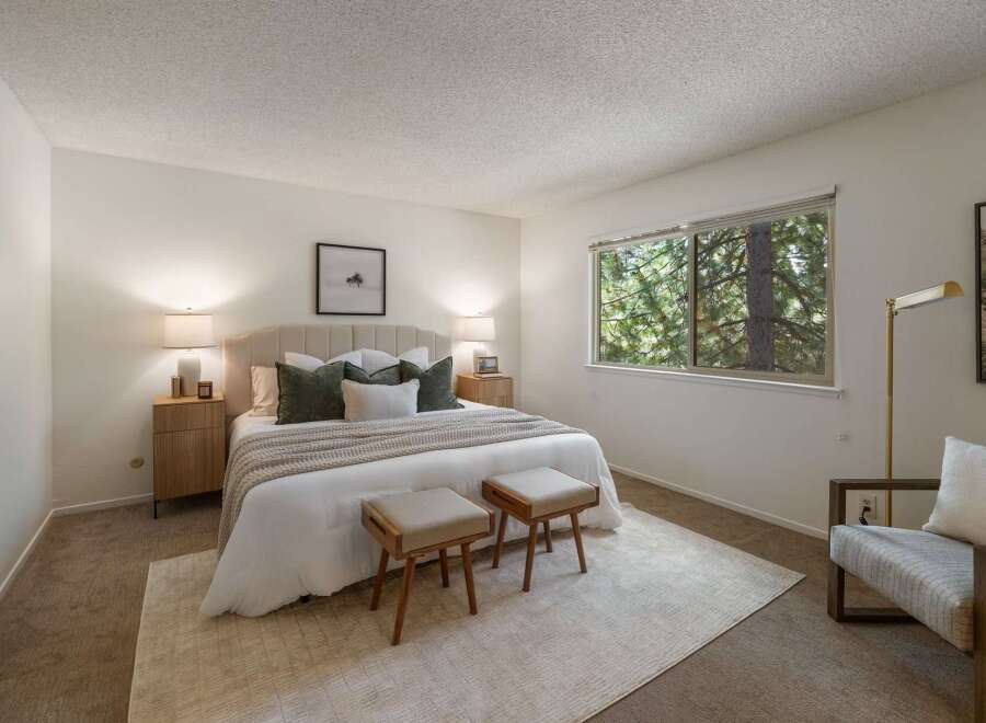 Experience serene living in this beautifully appointed bedroom, featuring a plush upholstered headboard and a cozy duvet.
