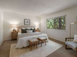 Experience serene living in this beautifully appointed bedroom, featuring a plush upholstered headboard and a cozy duvet.