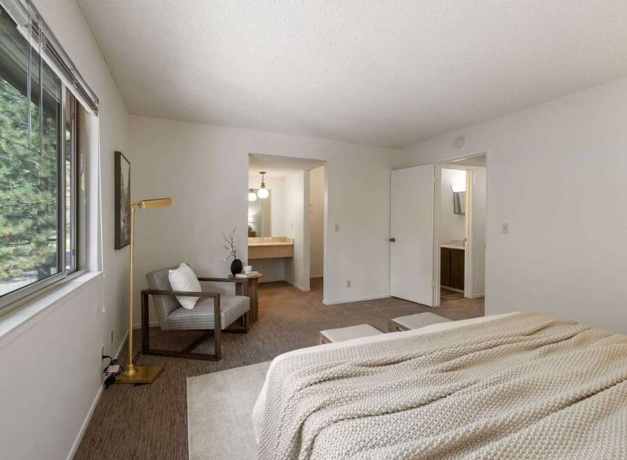 Experience comfort and style in this spacious bedroom, featuring a large window with scenic views and an en-suite bathroom for ultimate convenience.