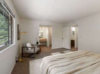 Experience comfort and style in this spacious bedroom, featuring a large window with scenic views and an en-suite bathroom for ultimate convenience.