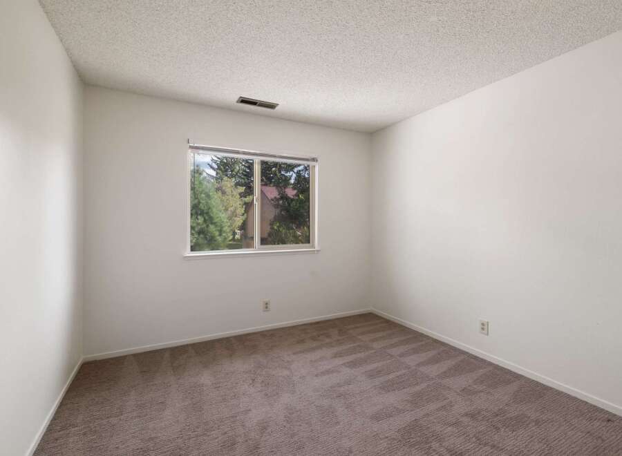 This spacious room features neutral carpeting and ample wall space, perfect for personalizing your living area.