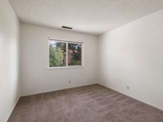 This spacious room features neutral carpeting and ample wall space, perfect for personalizing your living area.