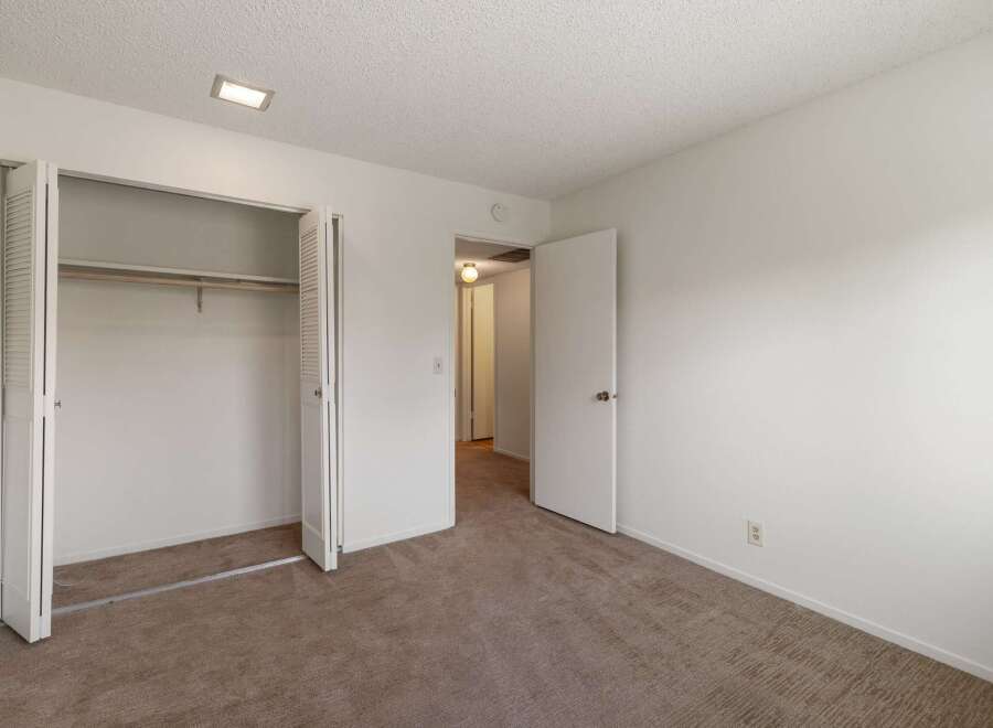 This spacious bedroom features a large closet with bi-fold doors, perfect for ample storage.