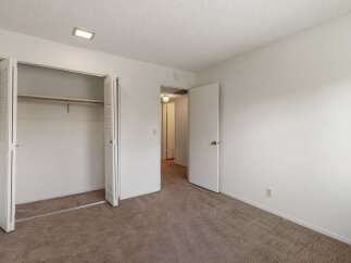 This spacious bedroom features a large closet with bi-fold doors, perfect for ample storage.