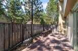 Enjoy outdoor living on this spacious wooden deck, perfect for entertaining or relaxing amidst a serene, tree-lined backyard.