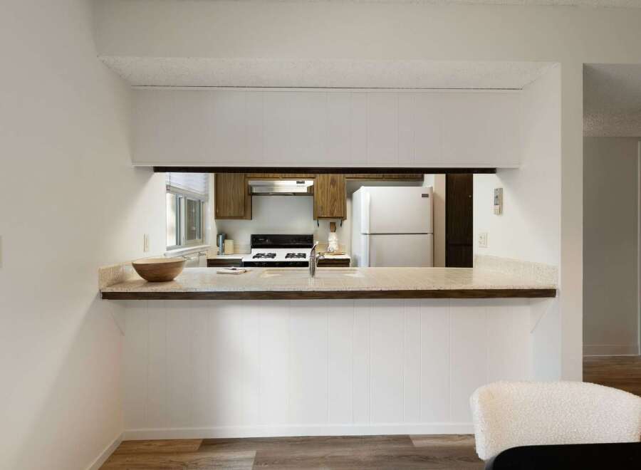 Discover this charming kitchen featuring a convenient pass-through window, perfect for entertaining guests.