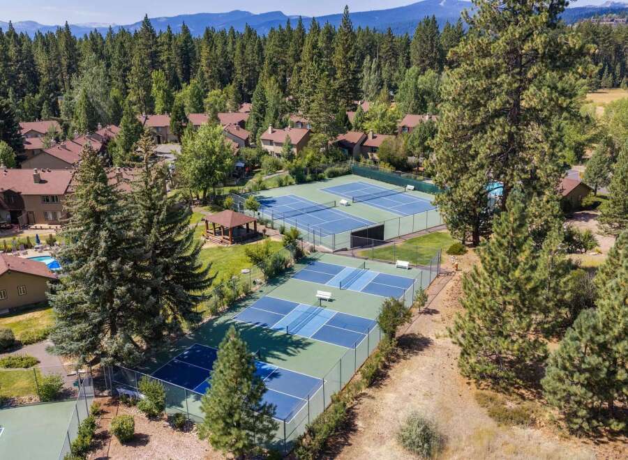 Experience resort-style living with this aerial view showcasing multiple tennis and pickleball courts, perfect for active residents.