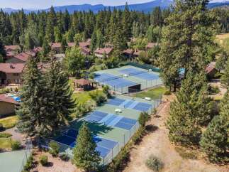 Experience resort-style living with this aerial view showcasing multiple tennis and pickleball courts, perfect for active residents.