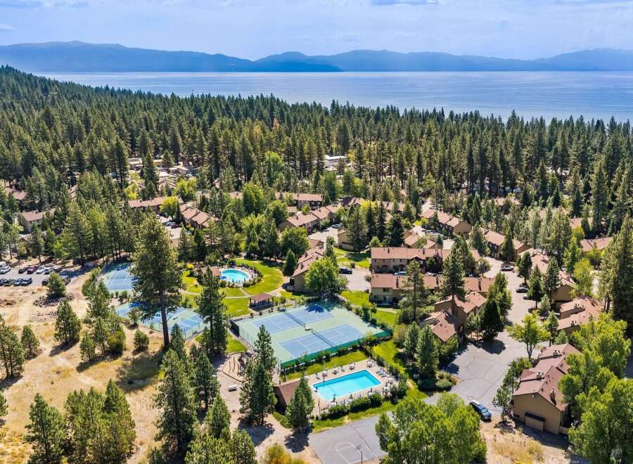 Discover this stunning property nestled amidst a lush pine forest, offering breathtaking views of a serene lake and distant mountains.