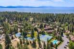 Discover this stunning aerial view of a resort-style community nestled amongst lush pine trees, offering a serene escape.