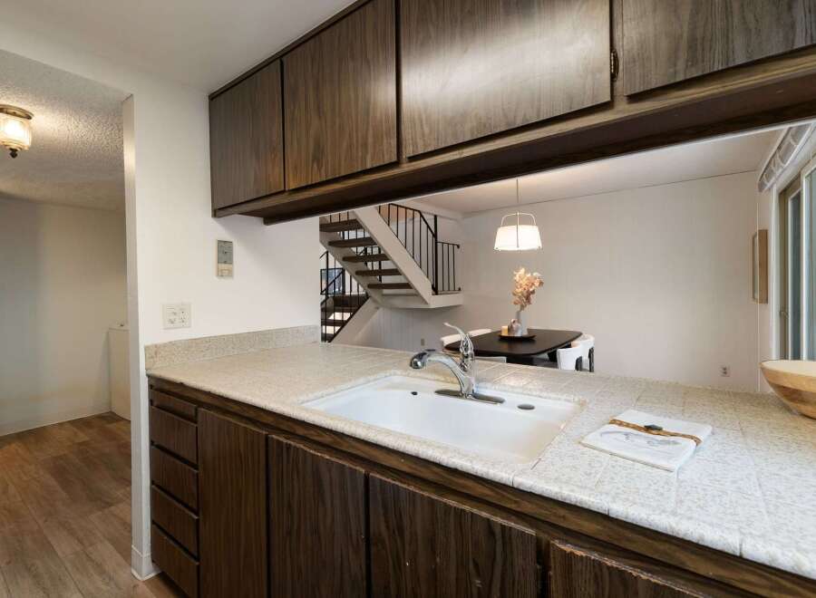 Discover this charming kitchen featuring a spacious sink and ample counter space, perfect for meal preparation.