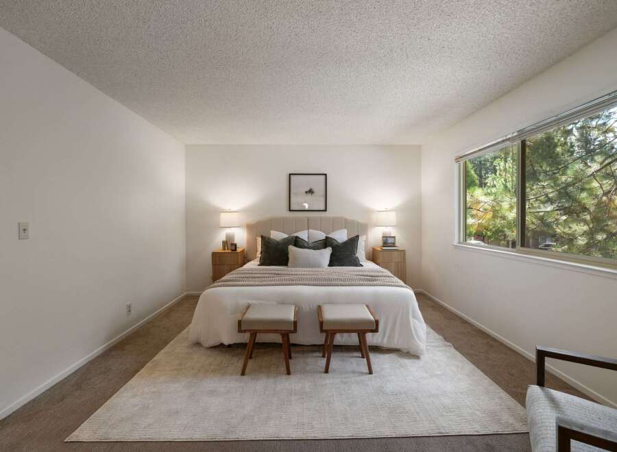 Experience serene living in this beautifully appointed bedroom, featuring a plush king-sized bed with a tufted headboard and elegant bedside tables with lamps.