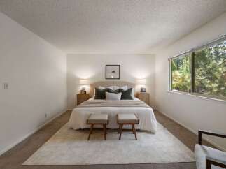 Experience serene living in this beautifully appointed bedroom, featuring a plush king-sized bed with a tufted headboard and elegant bedside tables with lamps.