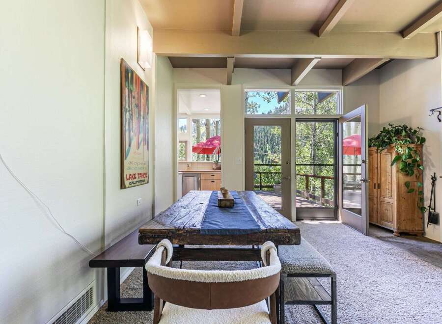 Experience rustic charm in this dining area featuring a substantial reclaimed wood table, perfect for gathering with loved ones.