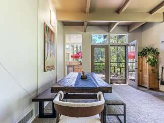 Experience rustic charm in this dining area featuring a substantial reclaimed wood table, perfect for gathering with loved ones.